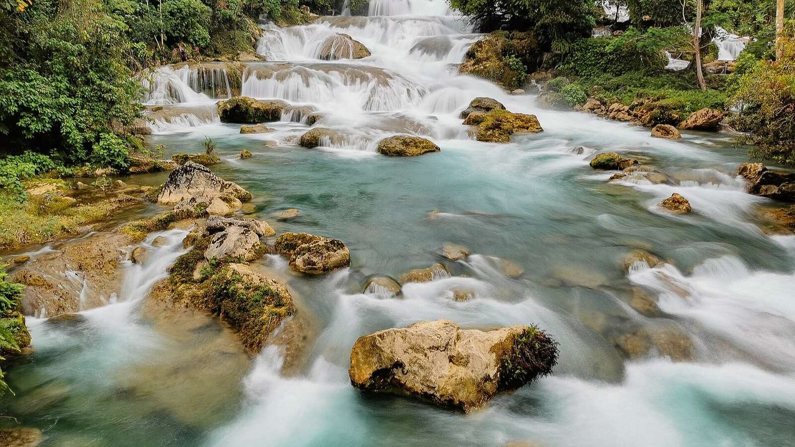 The tiered cascades of Aliwagwag Falls flowing over rocks in Cateel, Davao Oriental, Philippines