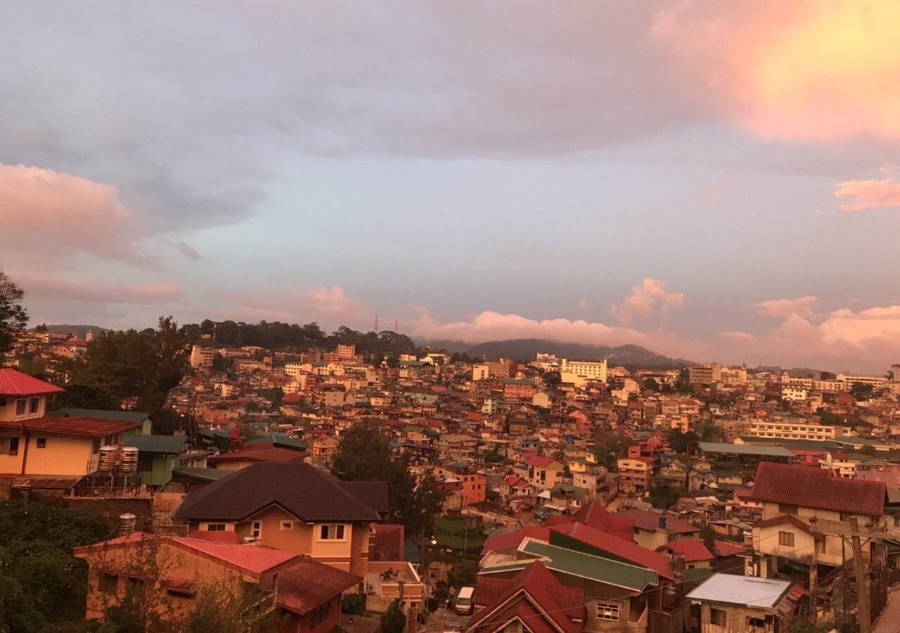 Hillside houses of Baguio City glowing at sunset in Benguet, Philippines