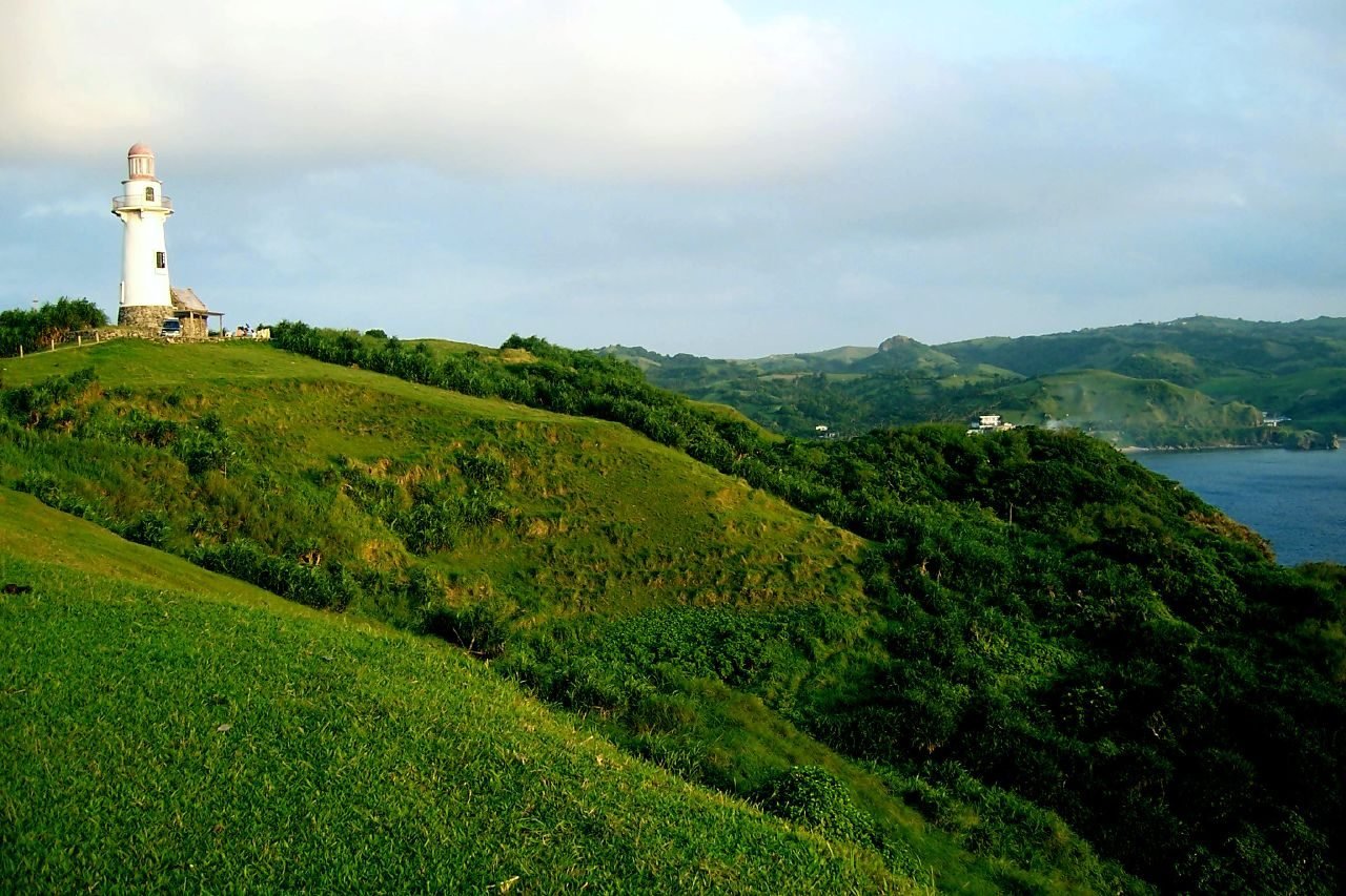 Basco Lighthouse standing on the green rolling hills above the sea in Batanes, Philippines