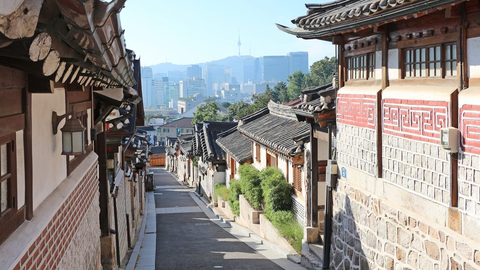 Traditional hanok houses in Bukchon Hanok Village with N Seoul Tower behind, Seoul, South Korea