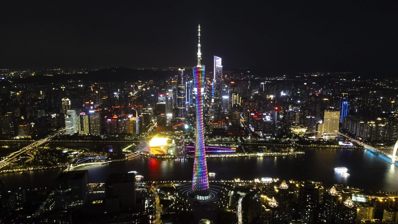 The Canton Tower lit at night above the Pearl River and Guangzhou skyline, China