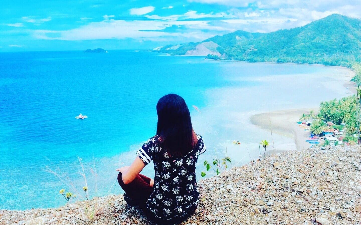 Turquoise water and a green headland on the coast at Barangay Tamban, Governor Generoso, Davao Oriental, Philippines