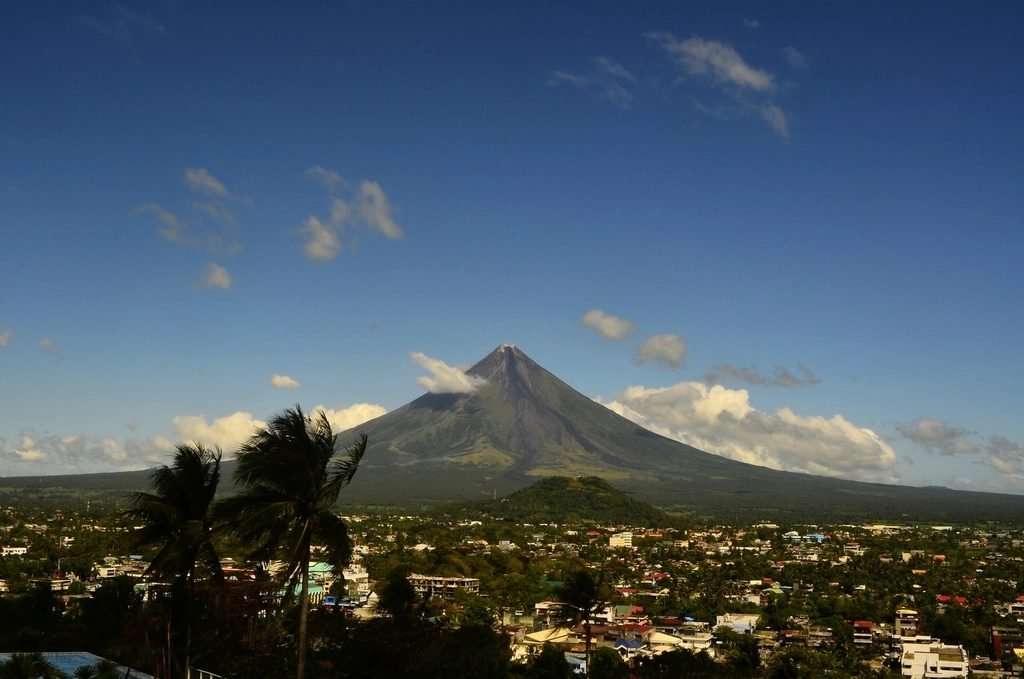The cone of Mayon Volcano rising above Legazpi City in Albay, Philippines