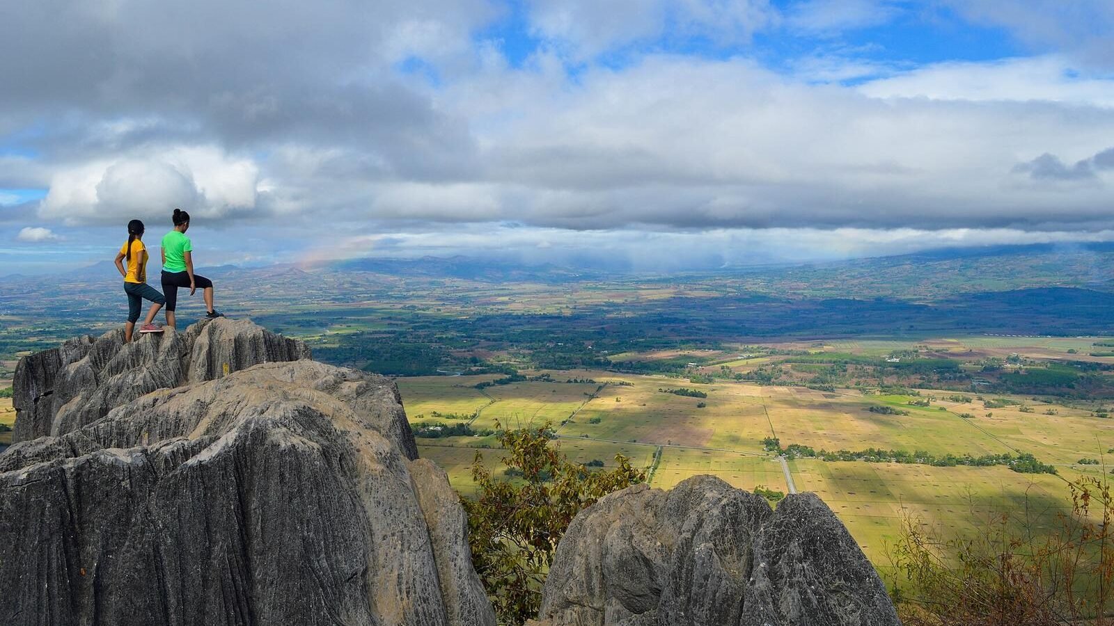 Hikers on the rocky outcrop of Mount Capistrano above the valley in Malaybalay, Bukidnon, Philippines