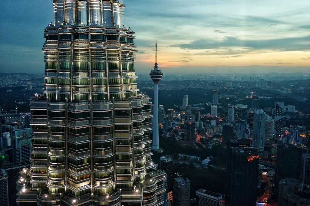 The Petronas Twin Towers and KL Tower above the Kuala Lumpur skyline at dusk, Malaysia