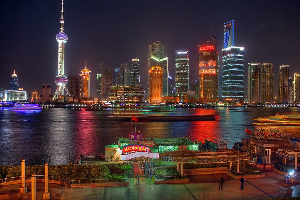 The Pudong skyline and Oriental Pearl Tower lit at night seen from the Bund, Shanghai, China